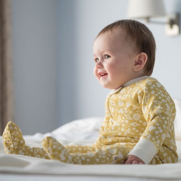Baby wearing yellow bee pattern sleepsuit
