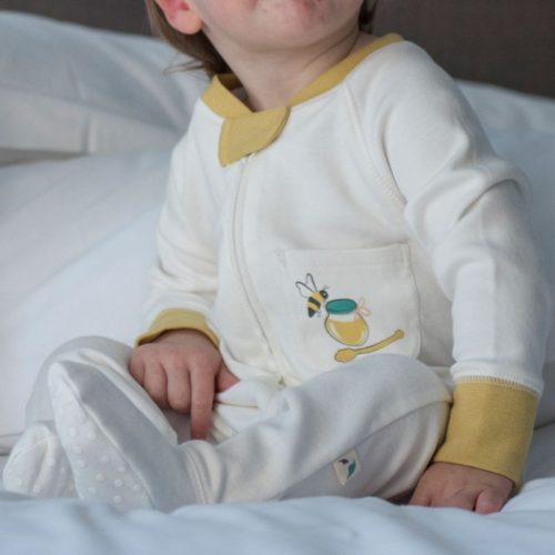 Baby wearing bee graphic sleepsuit