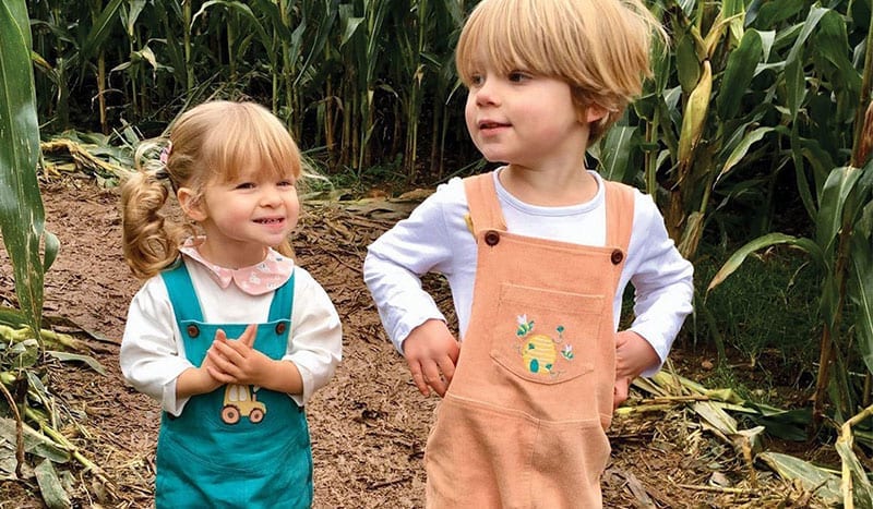 toddler and young child in corn field